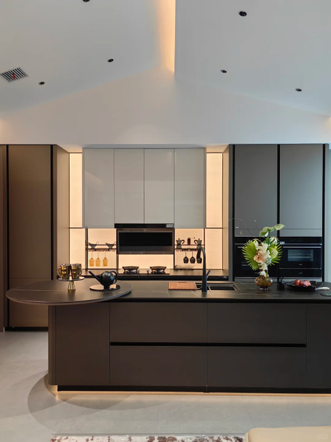 Cuisine ouverte de style moderne sophistiqu&eacute; avec des armoires &eacute;l&eacute;gantes et aux tons sombres